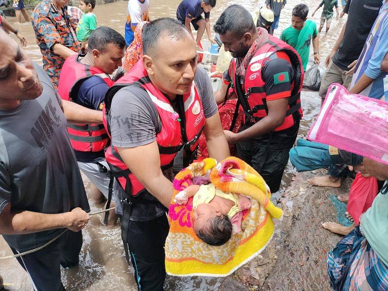 এক নবজাতককে উদ্ধার করে নিরাপদ স্থানে নিয়ে যাচ্ছেন ফায়ার সার্ভিসের সদস্যরা